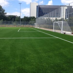 synthetic grass sports surfacing installation for football pitch and MUGA at school sports facility
