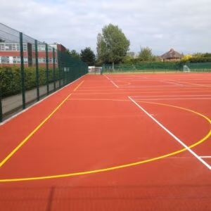 polymeric rubber sports surfacing installation for MUGA and outdoor multi sport court at school facility
