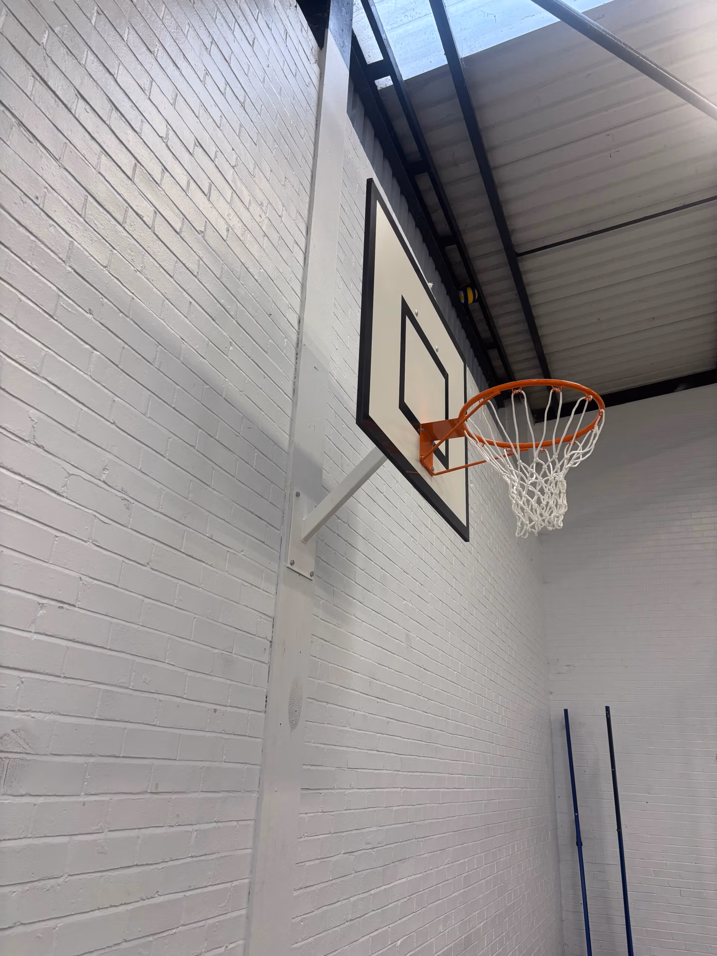 Fixed projection practice basketball goals installed in a school sports hall